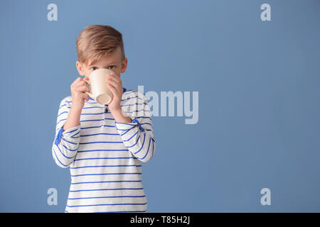 Cute little boy drinking hot cocoa sur un fond de couleur Banque D'Images