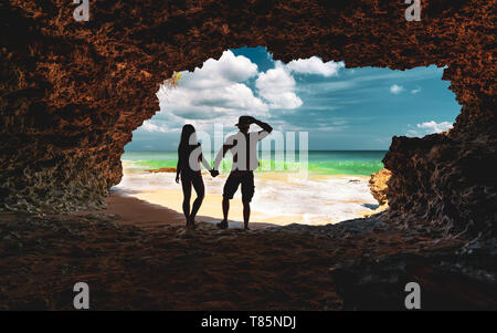 Jeune couple à la plage de caverne. Bali, Indonésie Banque D'Images