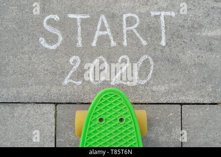 Début 2020 écrit à la craie sur les trottoirs gris, skateboard avant le texte Banque D'Images