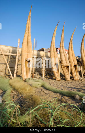 Les filets de pêche et les Caballitos de Totora (embarcations traditionnelles faites de roseau et utilisé pour la pêche et le surf) sécher sur la plage Huanchaco, Pérou Banque D'Images