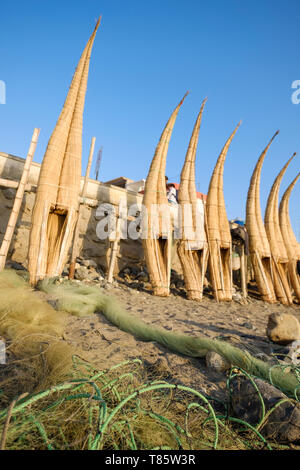 Les filets de pêche et les Caballitos de Totora (embarcations traditionnelles faites de roseau et utilisé pour la pêche et le surf) sécher sur la plage Huanchaco, Pérou Banque D'Images