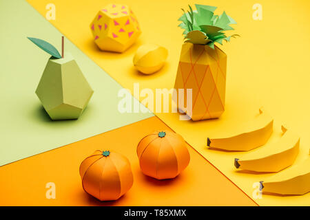 Divers origami coloré à la main sur les fruits verts, jaunes et orange papier Banque D'Images