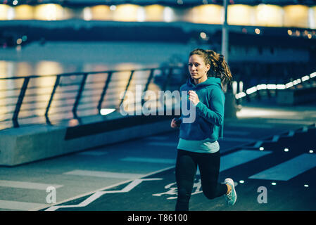 Woman jogging en ville la nuit Banque D'Images