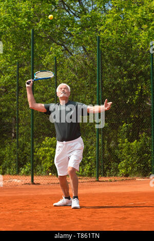 Senior man playing tennis Banque D'Images