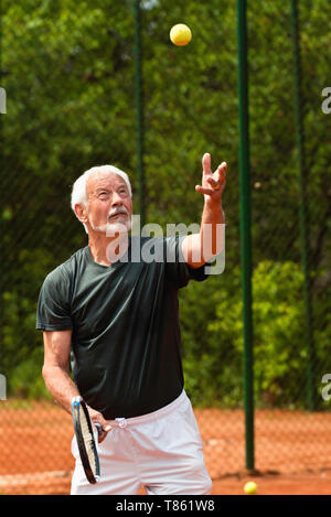 Senior man playing tennis Banque D'Images