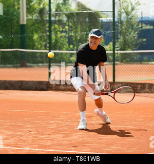 Senior man playing tennis Banque D'Images