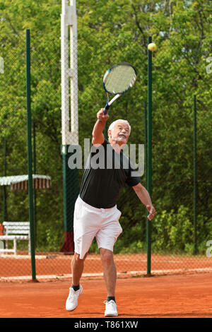 Senior male tennis player servant Banque D'Images