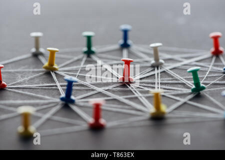 Focus sélectif des punaises de couleur connecté avec les cordes sur gray, réseau concept Banque D'Images