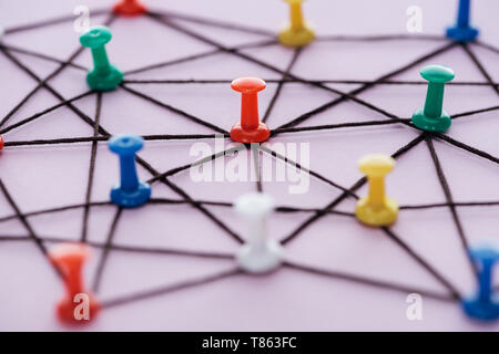 Focus sélectif de pousser broches connectées avec cordes isolé sur rose, le concept de réseau Banque D'Images