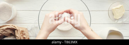 Vue panoramique shot of woman cracking egg dans un bol pendant la cuisson sur table Banque D'Images