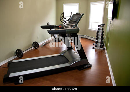 Un tapis roulant dans une salle de gymnastique à la maison avec d'autres équipements à l'intérieur d'un appartement ou maison Banque D'Images