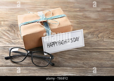 Boîte-cadeau avec des lunettes et 'Happy Father's Day' carte sur table en bois Banque D'Images