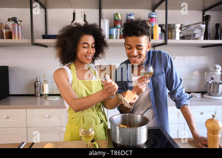 Jeune couple afro-américaines cooking together in kitchen Banque D'Images