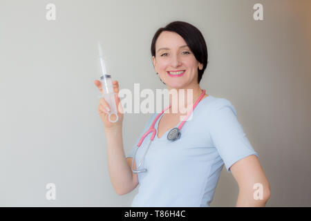 Beautiful smiling nurse holding syringe portrait isolé Banque D'Images