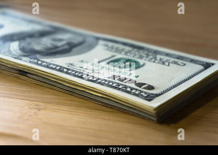 Crolled pile de 100 nouveaux billets d'un dollar sur fond de bois. Banque D'Images