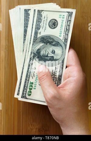 Crolled pile de 100 nouveaux billets d'un dollar sur fond de bois. Banque D'Images