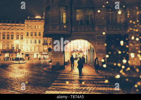 République tchèque, Prague - le 24 décembre 2018 : Night Street dans une ville européenne avec bokeh de lanternes de Noël, des silhouettes de personnes et façades de b Banque D'Images