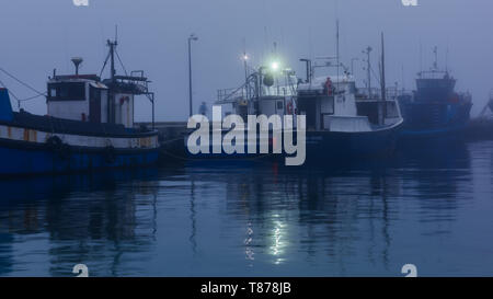 Une soirée en rouleaux de brouillard de la mer de l'Atlantique et des couvertures Hout Bay Harbour dans la brume sur la péninsule du Cap, près de Cape Town en Afrique du Sud Banque D'Images