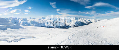 Vue panoramique vers le bas dans la vallée enneigée de montagnes alpines sur fond de ciel bleu Banque D'Images