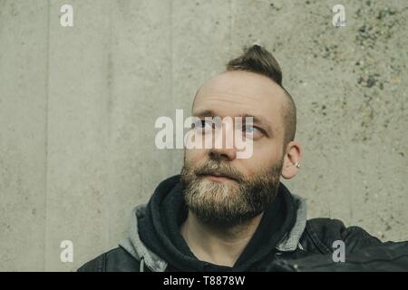 Heureux homme barbu inspiré à la face d'un mur Banque D'Images