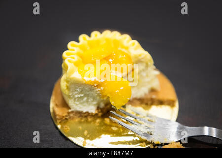 À moitié mangé Mango Cheese cake sur un fond uni Banque D'Images