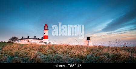 Un froid mais l'hiver lumineux lever du soleil avec du givre sur les herbes hautes sur la côte nord-est du phare du National Trust Souter Banque D'Images