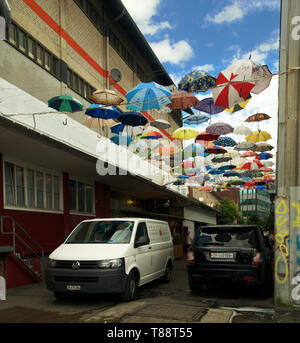 Les couleurs de l'image de parapluies accroché au-dessus d'un backstreet dans Hardbrücke, un artiste-localité infestée à Zürich Banque D'Images