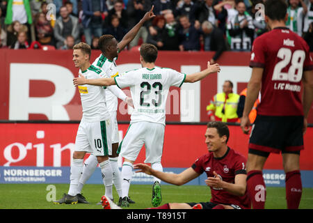 11 mai 2019, la Bavière, Nuremberg : Soccer : Bundesliga, 1er FC Nuremberg - Borussia Mönchengladbach, 33e journée à Max Morlock Stadium. Denis Zakaria (2e de gauche) de cheers Borussia Mönchengladbach avec ses collègues Thorgan Hazard (à gauche) et Jonas Hofmann (à droite) au sujet de son but à 0:4. Sur la droite se trouvent le Nuremberg Lukas Mühl (droite) et Georg Margreitter. Photo : Daniel Karmann/DPA - NOTE IMPORTANTE : en conformité avec les exigences de la DFL Deutsche Fußball Liga ou la DFB Deutscher Fußball-Bund, il est interdit d'utiliser ou avoir utilisé des photographies prises dans le stade et/ou le matc Banque D'Images