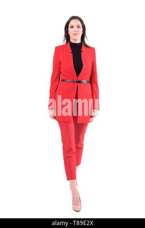 Jeune femme élégante réussie d'affaires balades en rouge costume élégant. Corps plein isolé sur fond blanc. Banque D'Images