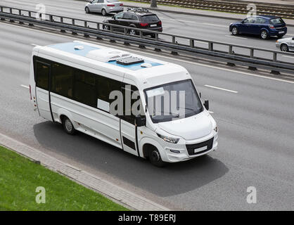Minibus blanc va sur la ville street Banque D'Images