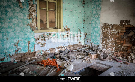 Vieilles chaussures dans une petite maison abandonnée dans la zone d'exclusion de Tchernobyl, le Bélarus a récemment ouvert pour le public d'avril 2019. Banque D'Images