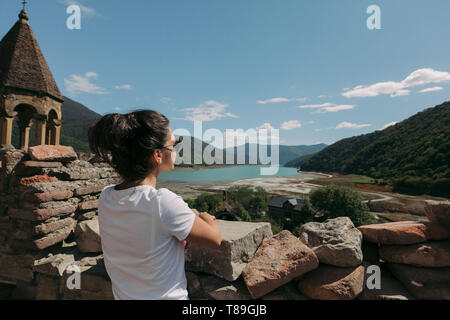 Jeune femme regarde l'église et à la forteresse en Géorgie en journée ensoleillée Banque D'Images