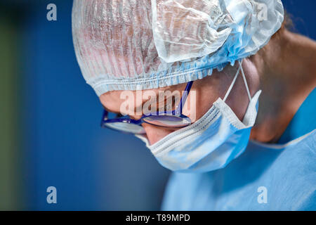Femme chirurgien en salle d'opération avec la réflexion dans les verres Banque D'Images
