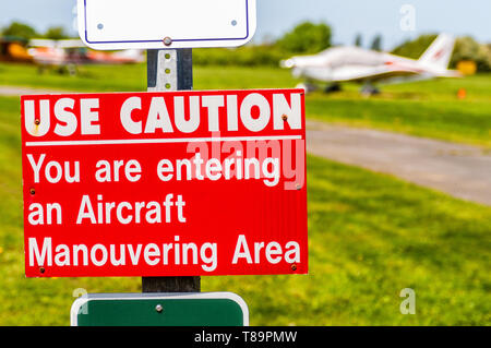 Startseite avion rouge et blanc, attention pendu sur poste à d'atterrissage. Banque D'Images