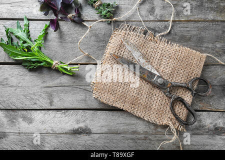 Ciseaux avec des herbes fraîches sur fond de bois Banque D'Images