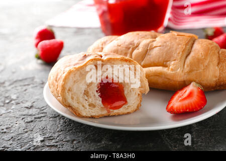 Délicieux croissants avec de la confiture de fraise sur la plaque, gros plan Banque D'Images