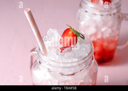 Limonade aux fraises savoureuses avec de la glace en pot Mason, gros plan Banque D'Images