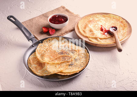 Crêpes minces délicieux avec de la confiture de fraise sur la table Banque D'Images