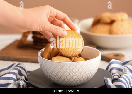 Woman taking cookie à partir de bol Banque D'Images