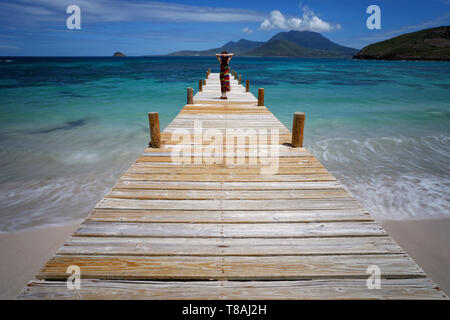 Femme sur un quai à Turtle Beach, Saint-Kitts. Banque D'Images