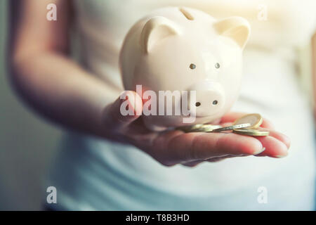 Female woman hands holding pink piggy bank et pièces en euros. Budget d'investissement de la richesse financière de la retraite d'entreprise de l'argent voyage concept Banque D'Images