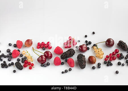 Les baies mûres de bleuets, framboises, groseilles, groseilles rouges et jaunes sont dispersées sur un fond blanc Banque D'Images