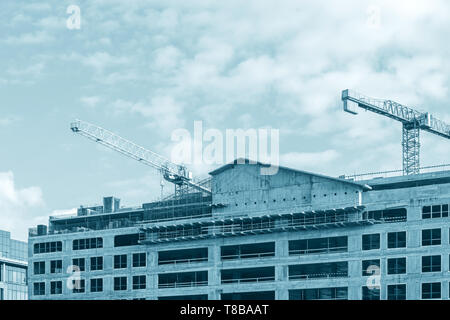 Chantier de construction d'échafaudages, des grues à tour contre fond de ciel bleu Banque D'Images