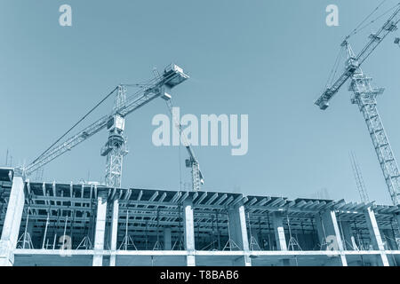 Ville construction site. building cranes against blue sky background. développement de l'infrastructure urbaine Banque D'Images