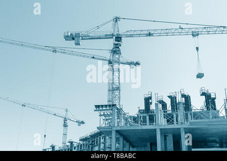 Bâtiment de béton de plusieurs étages en construction. grues à tour sur chantier. tonique libre Banque D'Images