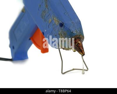 Vieux pistolet à colle chaude utilisée avec l'accent sur la colle fondue dégoulinant isolé sur fond blanc Banque D'Images