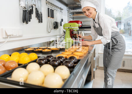 Confiseur travaillant sur un bon nombre de différents bonbons et desserts Banque D'Images