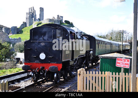 La classe Standard préservé 4MT 2-6-4t no. 80104 passe les ruines du château tel qu'il arrive à la station de Corfe Castle sur le chemin de fer Swanage dans le Dorset. Banque D'Images