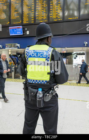 Un policier noir britannique de transport en service à la gare de Waterloo, Londres, Angleterre, Royaume-Uni Banque D'Images