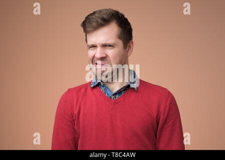 Pull homme mûr en rouge à la recherche avec l'expression d'incrédulité Banque D'Images